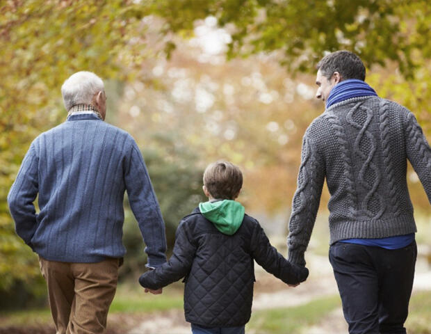 Grandfather, dad, and son discussing aged care financial planning in Ascot Vale whilst walking through a park