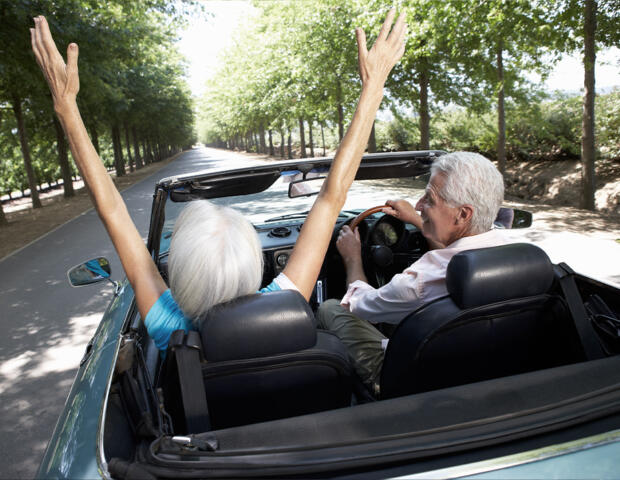 Pre-retirement couple in car with arms up having received positive financial planning advice in Ascot Vale