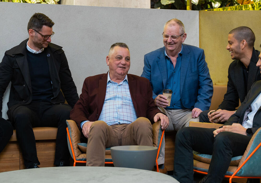 Abound partners seated in Melbourne office, talking and smiling