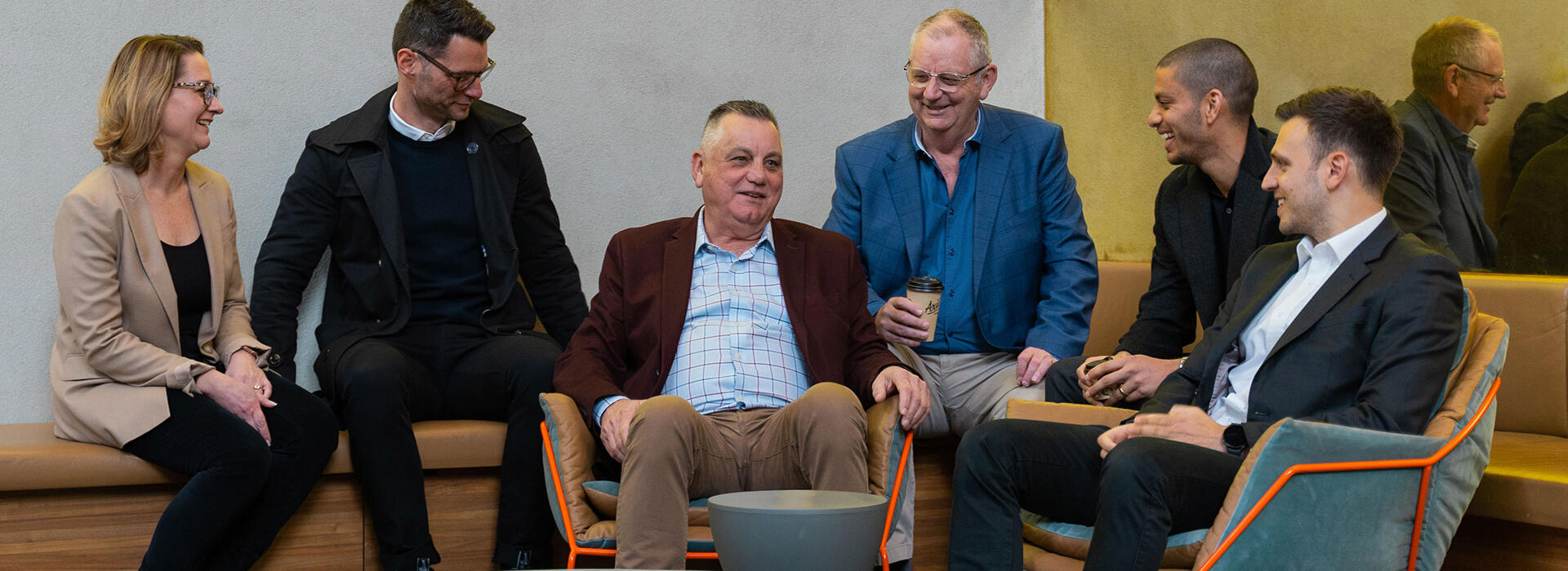 Abound partners seated in Melbourne office, talking and smiling