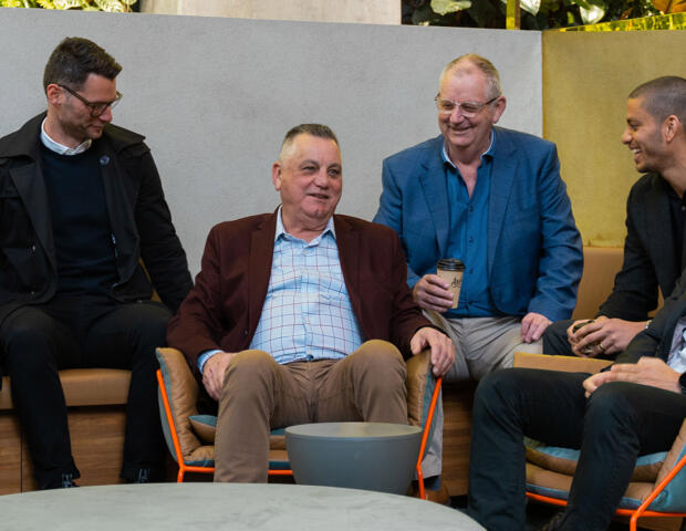 Abound partners seated in Melbourne office, talking and smiling